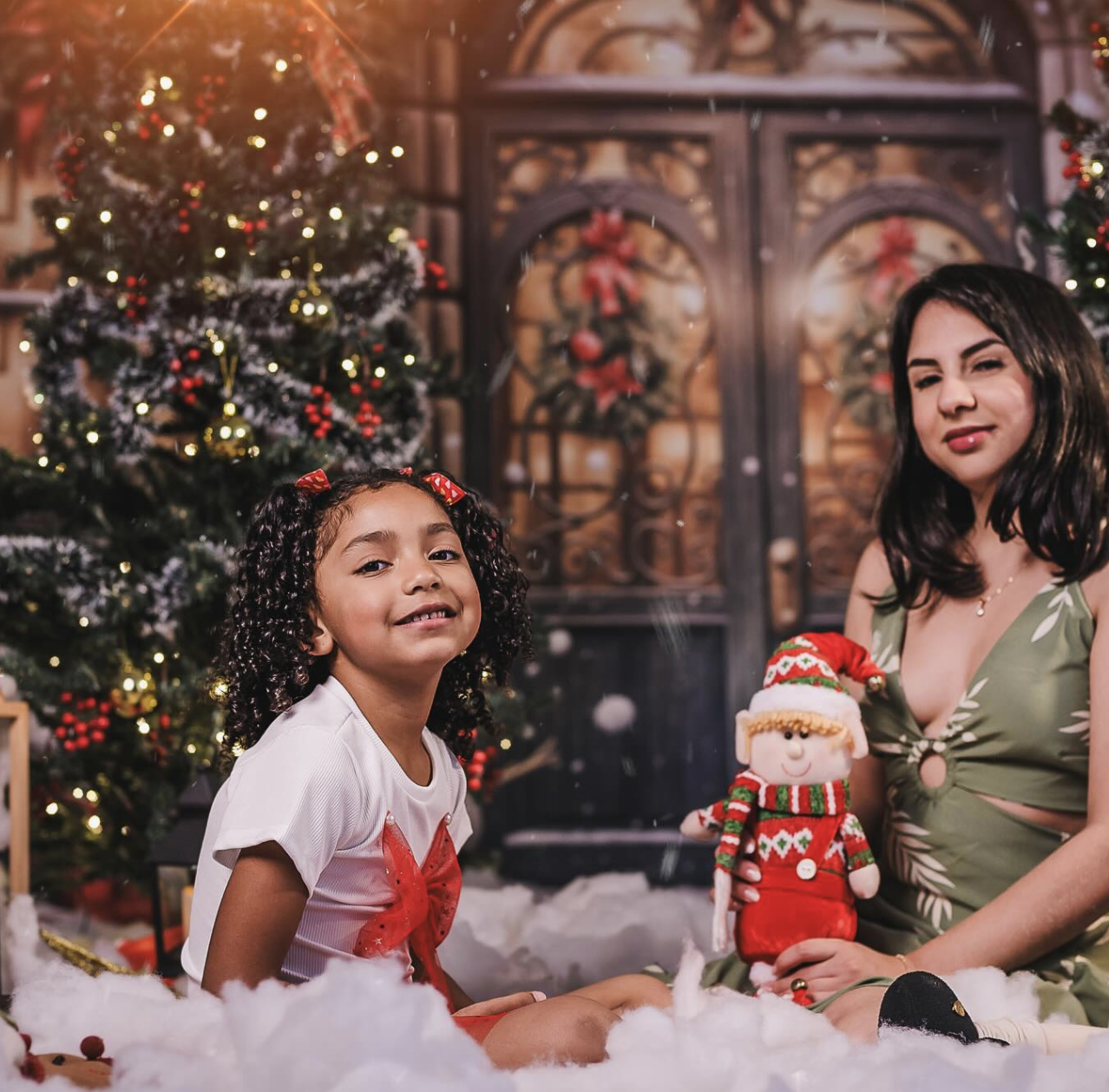 Mariana e filha em cena festiva ao lado da árvore de Natal